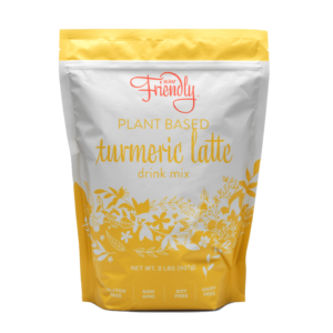 A yellow and white pouch labeled "Kaw Friendly Plant Based Turmeric Latte Drink Mix," featuring floral designs and icons indicating it is gluten-free, non-GMO, soy-free, and dairy-free. Net weight is 2 lbs (907 g).